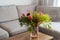 Vase with exotic protea flowers bouquet on coffee table with blurred background of modern cozy light living room with