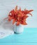 Vase orange lily congratulation on a wooden background textiles