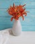 Vase orange lily retro bouquet holiday blooming design on a wooden background textiles