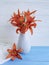 Vase orange lily retro holiday on a wooden background textiles