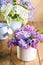 Vase with purple and white lilac and watering can