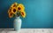 A vase of sunflowers on a table in front of a blue wall in brigh