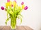 Vase with tulips agains white wall