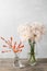 Vase with white chrysanthemum on a table of wooden planks