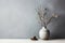 Vase with winter tree branch and pine cone decor at home table on minimal wall background in Scandinavian style interior design