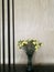 Vase of yellow carnation flower in the center of marble bar in the hotel lobby with blur background