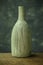 Vases with on rough distressed wooden shelf against grey wall.