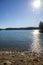 vast blue rippling water at Lake Lanier with the sun reflecting off the water and lush green trees with rocks along the banks