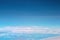 Vast bright blue sky view with clouds from airplane window, copy space