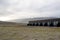 Vast green fields in Iceland with mountains and lodges