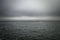 Vast grey ocean with asmall trawler fishing boat