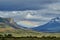 vast open landscape in Patagonia with dramatic sky and a rainbow over a valley