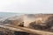 vast, open-pit mine in a desolate landscape with massive excavation equipment, dust clouds, and polluted water sources