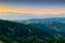 Vast panorama view of foggy valley in the Owl Mountains with silhouette of Sudetes mountain range at dusk. Poland.
