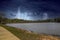 A vast rippling lake in the park surrounded by lush green trees with powerful storm clouds in the sky with lightning