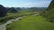 Vast valley with fields river road among hills in highland