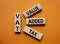 VAT - Value Added Tax symbol. Wooden cubes with word VAT. Beautiful orange background. Business and Value Added Tax concept. Copy