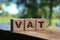 Vat on wooden cubes over blur background with copy space, financial concept