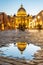 Vatican City by night. Illuminated dome of St Peters Basilica and St Peters Square. Group of tourists on Via della