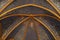 Vaulted ceiling with golden floral pattern on blue background and religious figures around the central vault stone