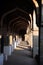 Vaulted corridor of the Hampi temple complex in sunlight. Cultural heritage, ancient architecture of India