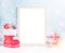 VBright christmas mock up with large photo frame: festive gift boxes, toys, and fir-cones in red santa`s boot under snow