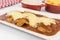 Veal parmigiana in a white platter with rice in and french fries in white background close