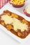 Veal parmigiana in a white platter with rice in and french fries in white background seen from above vertical