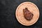 Veal steak on a bone on a black background. Free space for your text.