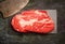 Veal steak marbled basalt, a knife for meat on a dark background