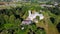 Vecauce Manor in Latvia Aerial View of the Pink Castle Through the Park. Vecauce Castle Tower With a Flying Latvian Flag.