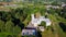 Vecauce Manor in Latvia Aerial View of the Pink Castle Through the Park. Vecauce Castle Tower With a Flying Latvian Flag.