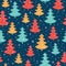 Vector blue, red, and yellow scattered christmas trees winter holiday seamless pattern on dark blue background. Great