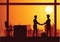 Vector illustration of a handshake of two businessmen,silhouette style sunset orange cityscape background