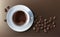 Vector illustration of a realistic style of white coffee cup with a saucer and coffee beans, top view, isolated on brown