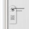 Vector realistic paper white blank door hanger on white realistic wooden door with metal silver handle background. Door