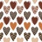 Vector seamless pattern with decorated hearts of different colors of chocolate on white