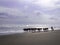 A veey beautiful view of the beach with a cowherd hearding the cows on the beach