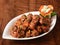 Veg Manchurian, Popular indo-chinese food made of cauliflower florets and other vegetable, served in a white plate over a rustic