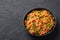 Veg Schezwan Fried Rice in black bowl at dark slate background. indo-chinese cuisine dish