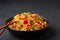 Veg Schezwan Fried Rice in black bowl at dark slate background. indo-chinese cuisine dish