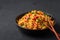 Veg Schezwan Fried Rice in black bowl at dark slate background. indo-chinese cuisine dish