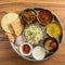 Veg Thali from an indian cuisine, food platter consists variety of veggies,paneer dish, lentils, jeera rice,roti, sweet dish, curd