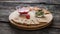 Vegan appetizer with avocado and beetroot dips, crackers and raw carrots served on wooden board