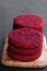 Vegan beetroot burgers on wooden board on black stone background