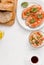 vegan breakfast of sandwiches with tomato, taboule bulgur salad and coffee on a white background.