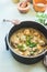 Vegan buckwheat balls in vegetables sauce in cooking pot on kitchen table background. Close up. Healthy home  food cooking concept