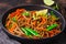 Vegan buckwheat soba noodles with vegetables in black plate on dark background