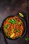 Vegan buckwheat soba noodles with vegetables in black plate on dark background, top view