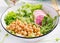 Vegan Buddha bowl with chickpeas, watermelon radish, cucumber and peas sprouts.